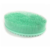 Brosse sensorielle de forme ovale, en silicone vert, avec de nombreux picots fins.