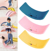 Ensemble de trois planches d’équilibre (rose, jaune, bleue) montrées avec un enfant qui joue et dessine dessus