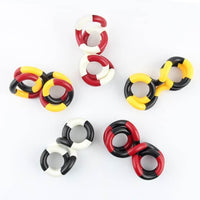 Plusieurs tortillons de manipulation composés de maillons rouges, jaunes, noirs et blancs, disposés en cercle
