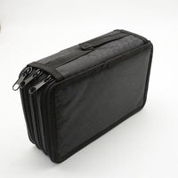 Gros plan d’une trousse à compartiment noire, montrant un motif en nid d’abeilles et plusieurs zips