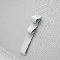 Deux languettes élastiques grises superposées à l’intérieur d’une trousse à compartiment noire